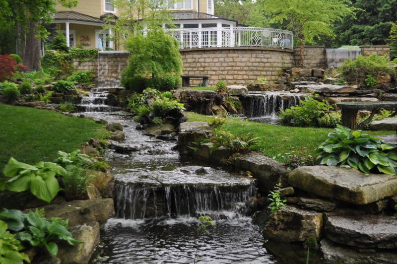 paysagiste-GINASSERVIS-min_landscaping-rock-louisville-ky-traditional-landscape-and-boulders-brick-wall-bushes-grass-koi-law